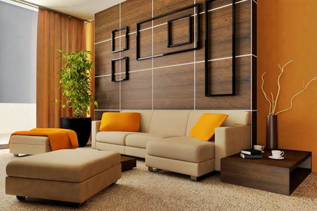 Salone arredato con cuscini di colore arancio e parete ocra