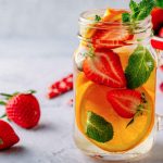 Infused detox water with orange, strawberry and mint. Ice cold summer cocktail or lemonade.