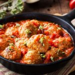Meatballs in tomato sauce with dried oregano in a rustic vintage