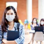 Portrait of young asian student wear mask looking at camera hold