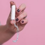 Woman's hand holding a clean cotton tampon