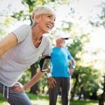 Beautiful mature couple jogging in nature living healthy