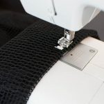 Ripiegare il bordo superiore del tessuto a rete sopra la cintura della donna e cucire la parte di sotto. Ricordatevi di cucire il tessuto a rete fino ai bordi della zip.