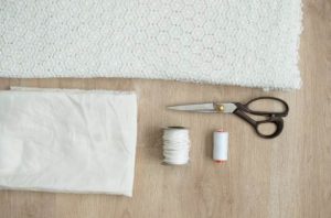 Occorrente per il mini dress: tessuto in pizzo, tessuto in cotone, forbici e filo.