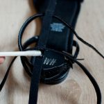 Con un punto di colla inizia ad applicare le striscioline di pelle orizzontali.