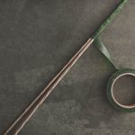 Prendete 3 steli e avvolgeteli con il nastro adesivo verde (potete comprarlo dal fioraio) per ricavarne un unico stelo.