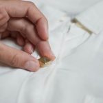 Assicuratevi che la camicia sia chiusa e applicate le borchie sopra i bottoni.