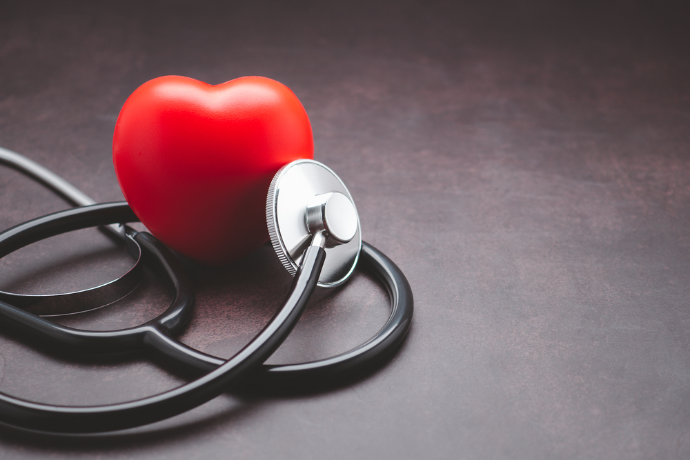 A stethoscope and red heart laid on vintage background. Close-up